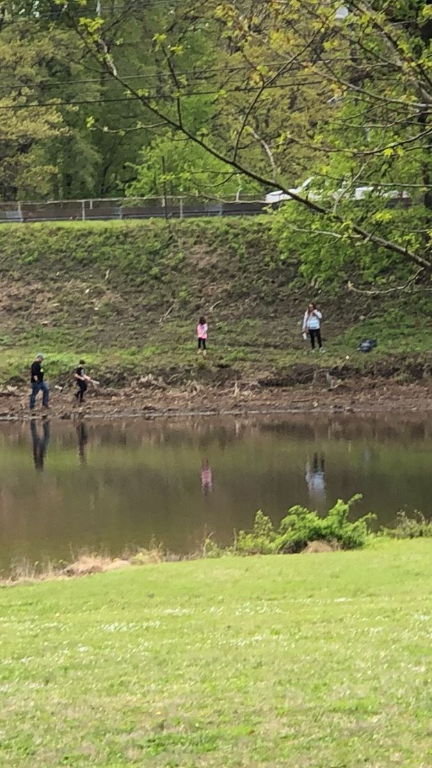 People Across the Lake Picking up Trash