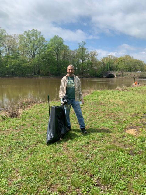 Man Standing Next to a Bag Full of Recovered Trash